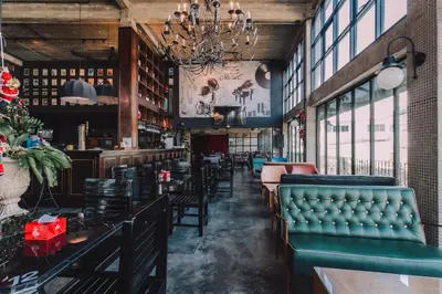a restaurant with green leather chairs and a christmas tree at Quip Bed & Breakfast in Phuket Town