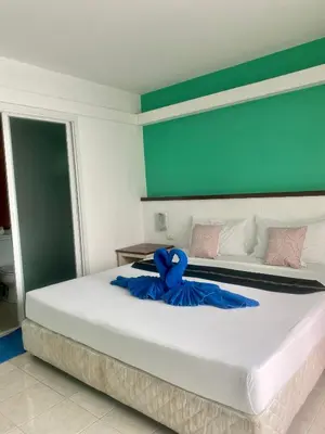 a bedroom with a large bed with a blue ribbon on it at Kata Guesthouse Tuscany in Kata Beach
