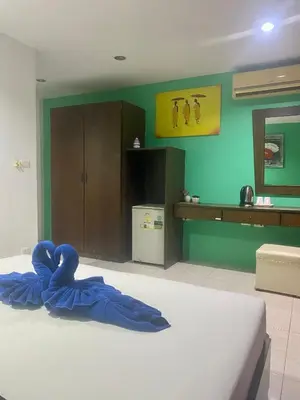 a bedroom with a bed with a blue blanket on it at Kata Guesthouse Tuscany in Kata Beach