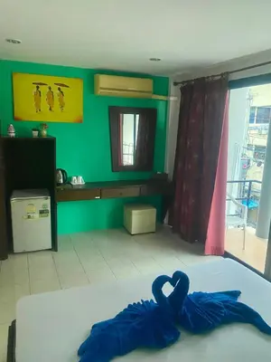 a room with a bed with a blue towel on it at Kata Guesthouse Tuscany in Kata Beach