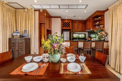 a dining room table with plates and wine glasses at VILLA TOGIAN Private Pool Naiharn beach in Rawai Beach