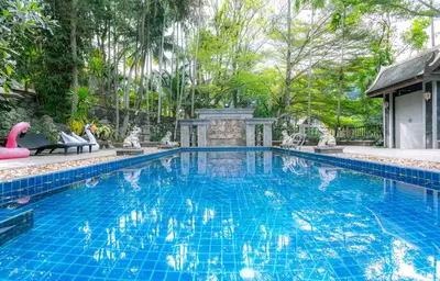 a swimming pool with a pink flamingo in a yard at Lawootrip Villa in Patong Beach
