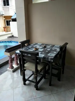 a black table and chairs with a table and a pool at Thalassa in Nai Harn Beach