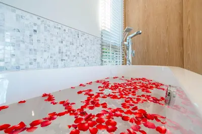 a white bath tub with red flowers on it at Trichada Tropical in Bang Tao Beach