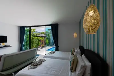 a bedroom with two beds and a large window at Lespalm Taraburi Pool Villa SHA Plus in Thalang