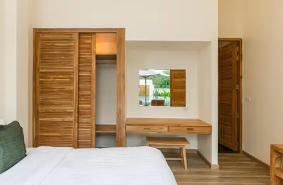 a bedroom with a bed and a desk in it at Lespalm Taraburi Pool Villa SHA Plus in Thalang