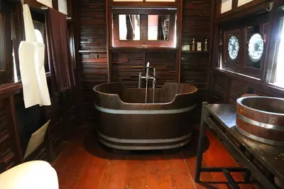 a wooden bathroom with a tub and a sink at Le Passe-Temps in Tha Lane Bay