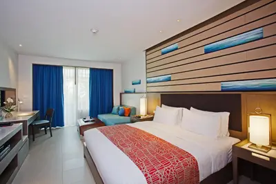 a hotel room with a large bed and a desk at Holiday Inn Resort Phuket, an IHG Hotel in Patong Beach