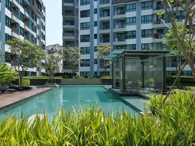 a swimming pool in front of a tall building at 4 Floor - Centrio Condominium in Phuket town in Phuket Town
