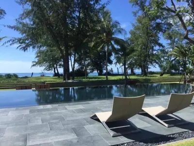 a swimming pool with two lounge chairs next to it at Baan Mai Khao in Mai Khao Beach