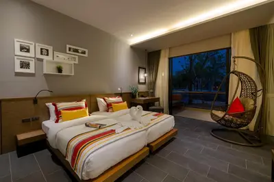 a bedroom with a large bed and a swing at The Gallery Hotel Nai Harn in Nai Harn Beach