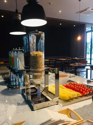 a counter with a buffet of food on a table at The Gallery Hotel Nai Harn in Nai Harn Beach