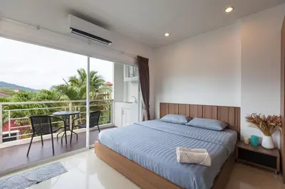 a bedroom with a bed and a balcony at Number 4 Phuket in Nai Harn Beach
