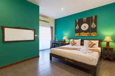 a bedroom with a bed with a green wall at Seeka Boutique Resort in Patong Beach