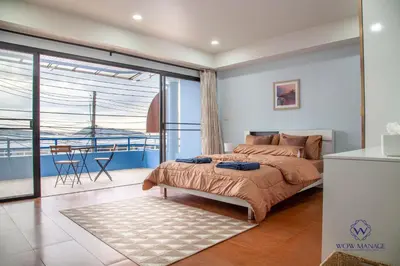 a bedroom with a bed and a view of the ocean at Enjoy Sunset Rainbow Alley - WOW Townhouse at Patong Hill in Patong Beach