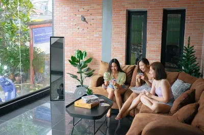 three women sitting on a couch in a living room at Tall Tree Kata Phuket in Kata Beach