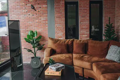a brown couch sitting in front of a brick wall at Tall Tree Kata Phuket in Kata Beach