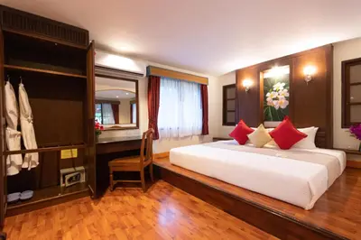 a bedroom with a large white bed and a desk at Aochalong Villa Resort & Spa - SHA Plus in Chalong