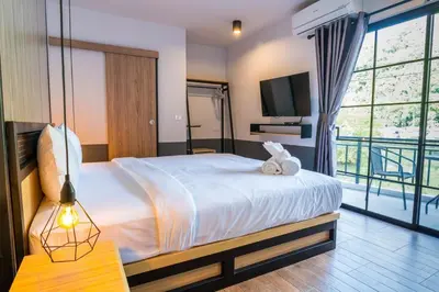 a bedroom with a large bed and a tv at PP GRAND KAMALA HOTEL-SHA Extra Plus in Kamala Beach