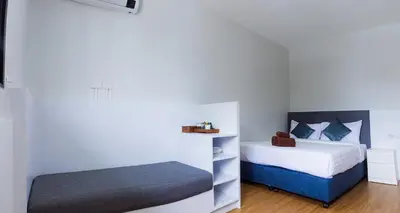 a bedroom with two beds and a bench in it at Silla Patong Boutique - Beach Walk Access in Patong Beach