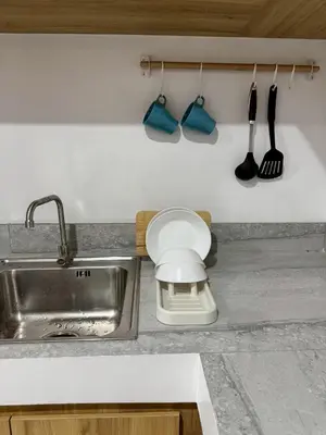 a kitchen counter with a sink and utensils at Baan Trok Bedroom Studio Maikhao in Mai Khao Beach