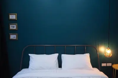 a blue bedroom with a bed with white pillows at Baan Trok Bedroom Studio Maikhao in Mai Khao Beach