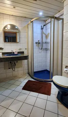 a bathroom with a shower and a toilet and a sink at Pension Zum Ross in Karon Beach