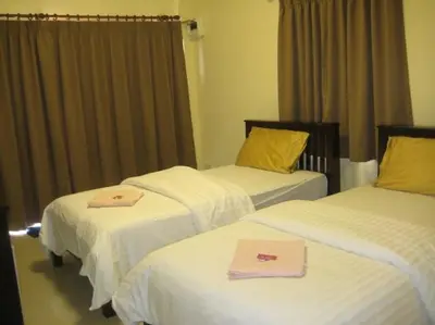 a hotel room with three beds with towels on them at Naga Peak Resort in Ao Nang Beach