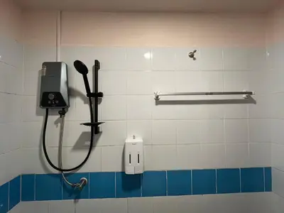 a bathroom stall with a phone and a shower at Sabai House in Phi Phi Don