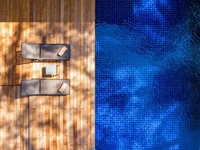 a close up of a swimming pool with chairs next to it at Grand Villa Noi in Natai Beach