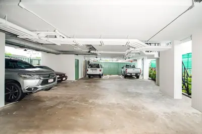 a garage with two cars parked in it at beHOME Phuket in Nai Yang Beach
