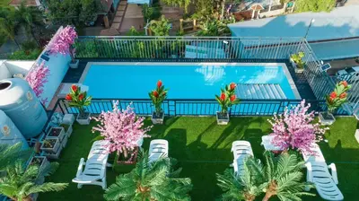 an overhead view of a swimming pool with chairs and trees at Happy 99 Guest house in Patong Beach