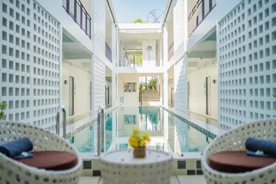 a room with a pool and two chairs and a table at The Rubber Hotel Phuket in Thalang