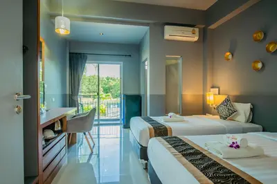 a hotel room with two beds and a bathroom at The Rubber Hotel Phuket in Thalang