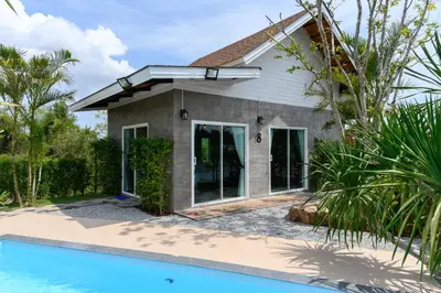 a house with a swimming pool in front of it at Loftpical Resort in Phuket Town