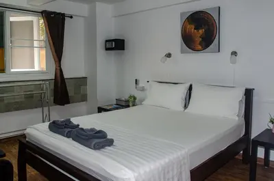 a bedroom with a bed with a pair of shoes on it at Allstar Guesthouse in Karon Beach