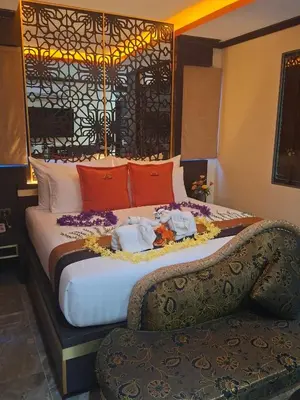 a hotel room with a large bed with two towels on it at BAB ALHARA HOTEL in Patong Beach