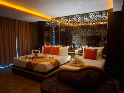 a hotel room with two beds and a chair at BAB ALHARA HOTEL in Patong Beach
