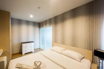 a bedroom with a large white bed and a dresser at Aonang Ocean View Studio ( The Sea Condo ) in Ao Nang Beach