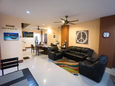 a living room with leather furniture and a dining room at Mellow Space Boutique Rooms in Karon Beach