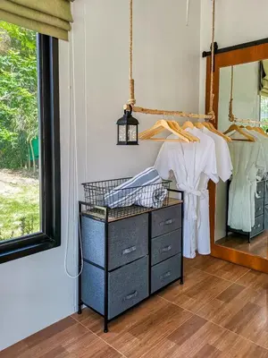 a dresser in a room with a mirror at Coconut Wells Phuket in Chalong