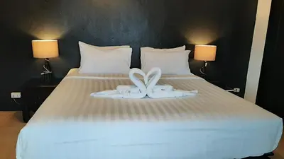 a bed with two white towels on it at Big Boys' Bed & Burger - Patong Beach in Patong Beach