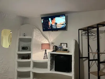 a living room with a tv on a wall at Big Boys' Bed & Burger - Patong Beach in Patong Beach