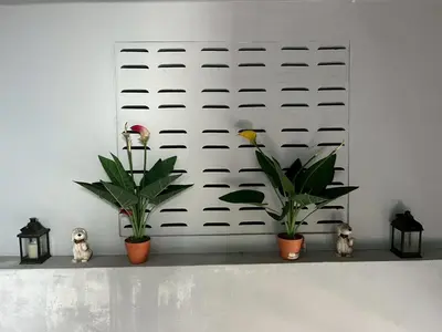 a white wall with two plants and two lights at Easy Loft Hostel in Phuket Town