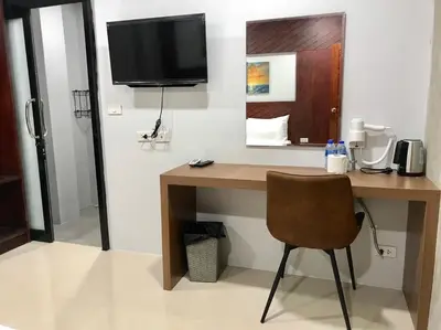 a desk with a television and a chair in a room at Easy Loft Hostel in Phuket Town