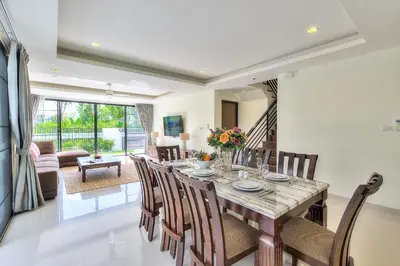 a dining room and living room with a table and chairs at 5bdr Pool Villa In Laguna Park #45 by Capital Pro in Bang Tao Beach