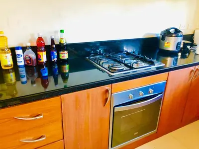 a kitchen counter with a stove and bottles of alcohol at Thai Family karon Pool Villa \u6cf0\u5982\u5bb6\u5361\u4f263\u5367\u6cf3\u6c60\u522b\u5885 in Karon Beach