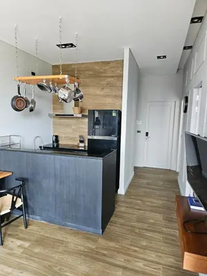a kitchen with a black counter and wooden floors at Lucky Holidays in Saturdays Residence in Rawai Beach