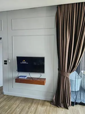 a living room with a television and a curtain at Lucky Holidays in Saturdays Residence in Rawai Beach