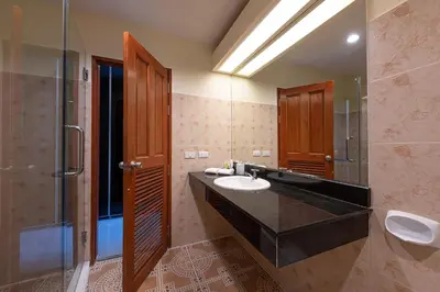 a bathroom with a sink and a shower and a mirror at Blue Beach Grand Resort And Spa in Rawai Beach